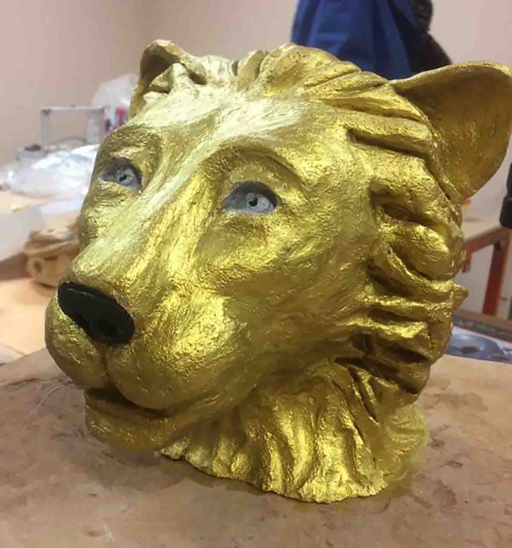 Sculpture d'une tête de lion dorée réalisée par Béatrice, ancienne patiente du cancer qui utilise l'art comme thérapie