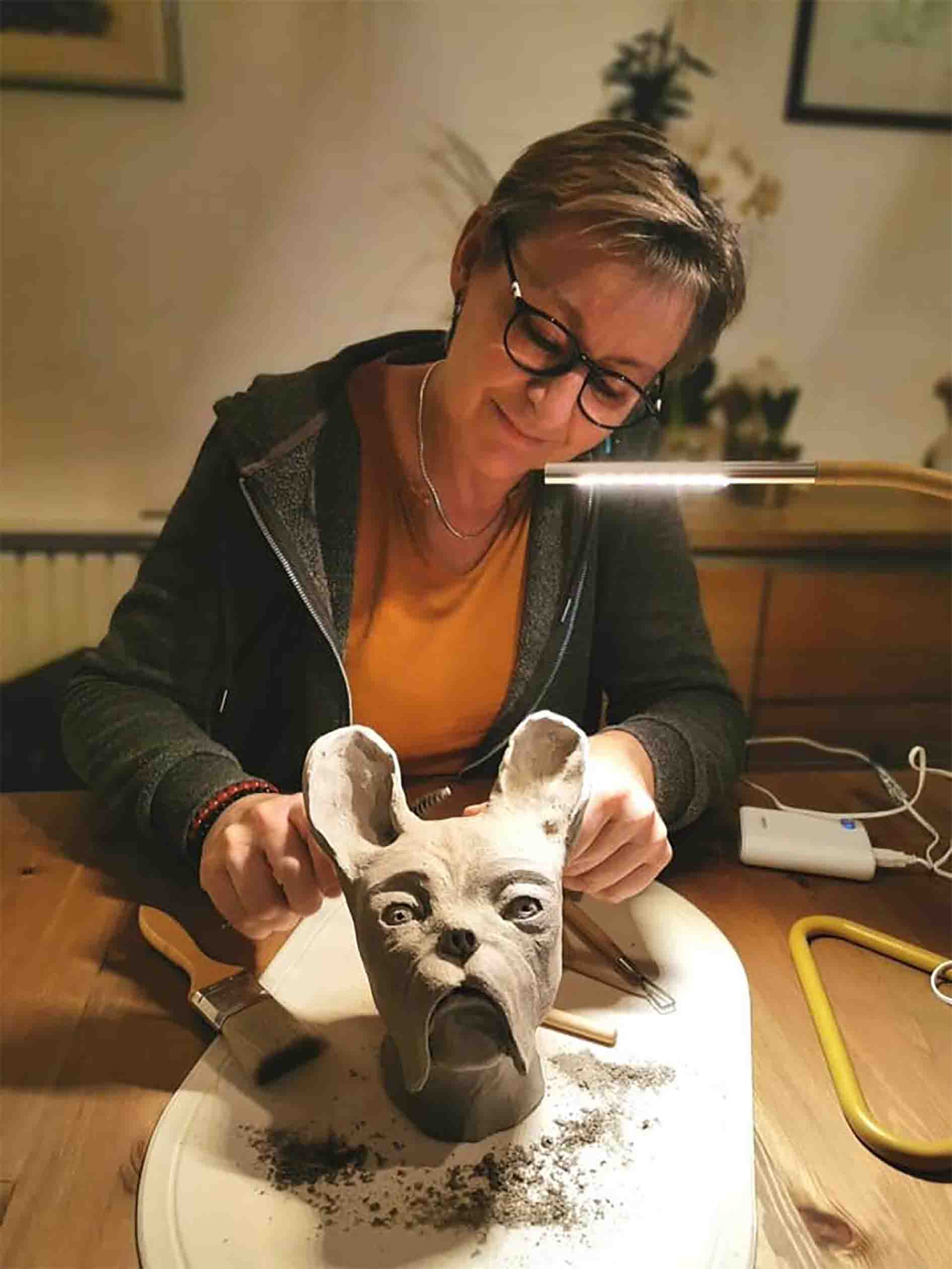 Photo de Béatrice, ancienne patiente du cancer, en pleine action de sculpter, une forme d'art-thérapie