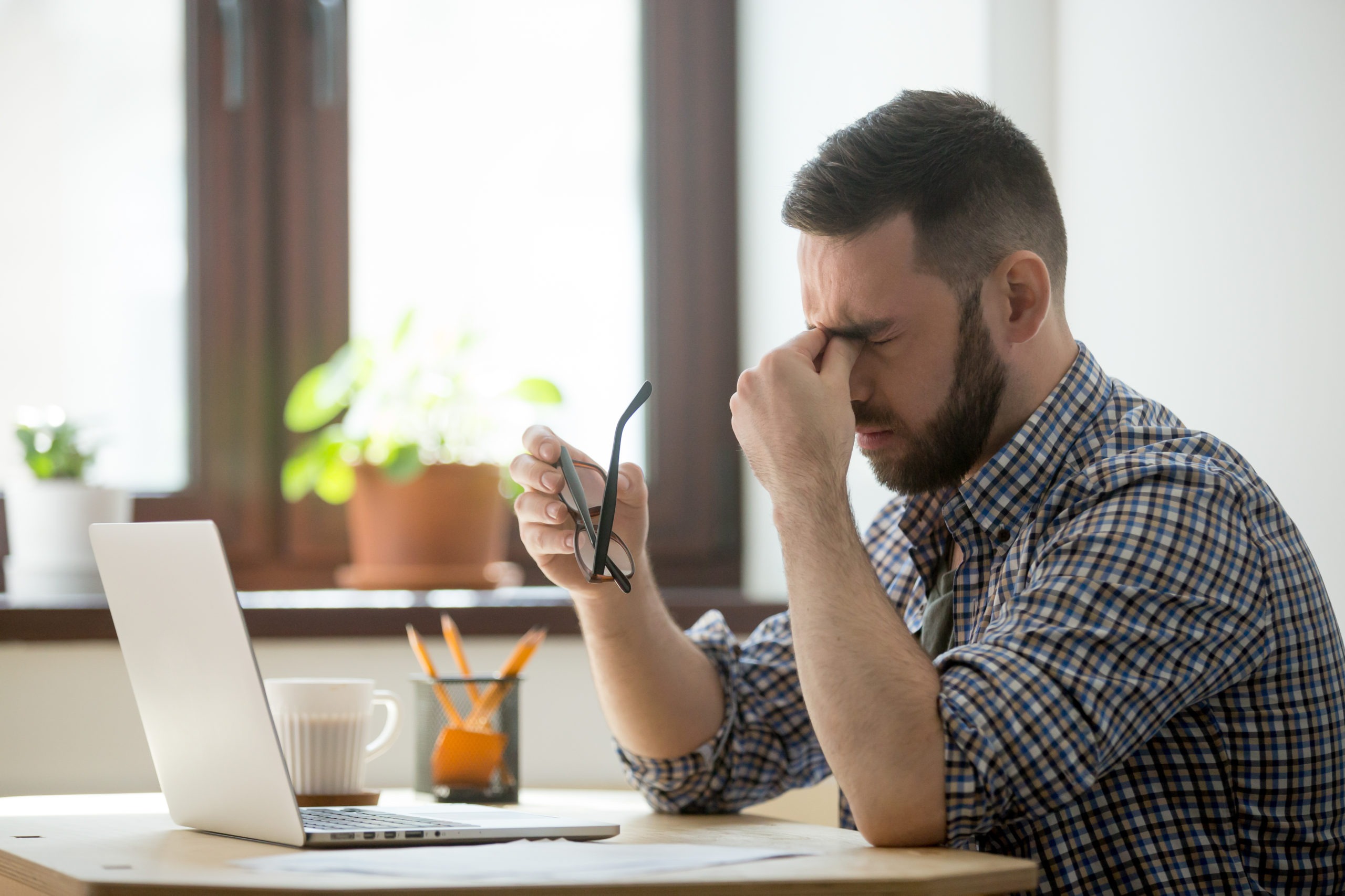 photo d'un homme stressé, fatigué, avec mal de tête, symptômes possibles d'un cancer